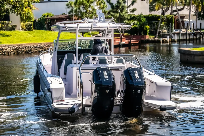 Slide: The Image of 2024 Axopar 37 Sun Top boat with dual Mercury engines on a sunny waterway. - 34