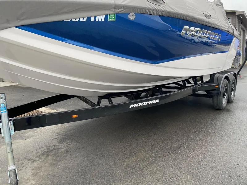 Slide: The Image of 2023 Moomba Mojo boat on trailer, covered and parked on wet pavement. - 8