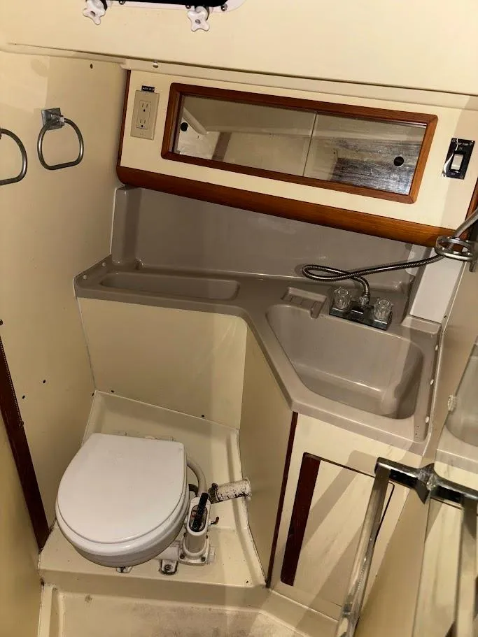 Slide: The Image of 1989 Pearson 31 sailboat bathroom with sink, mirror, and toilet. - 21