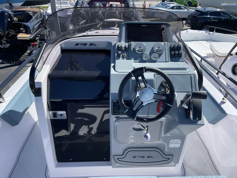 Slide: The Image of 2024 Ranieri 275 SL boat interior at a marina, showcasing helm and seating area. - 22