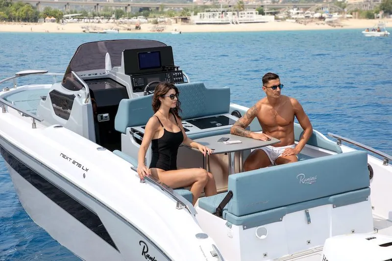 Slide: The Image of 2024 Ranieri 275 SL boat with two people relaxing on deck in sunny weather. - 3