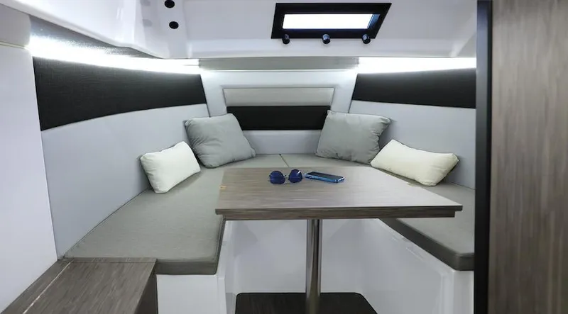 Slide: The Image of 2024 Ranieri 275 SL boat interior with cushioned seating and table. - 4