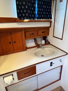 Slide: The Image of Bathroom interior of a 1996 Grand Banks Classic yacht with wooden cabinetry and nautical curtains. - 11