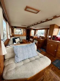 Slide: The Image of Interior of a 1996 Grand Banks Classic yacht with cozy seating and wooden furnishings. - 16