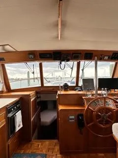 Slide: The Image of Interior of a 1996 Grand Banks Classic yacht, featuring a wooden helm and navigation equipment. - 23