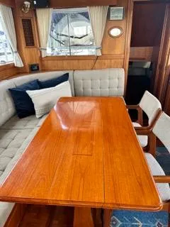 Slide: The Image of Interior of 1996 Grand Banks Classic yacht with wooden table and cushioned seating. - 24
