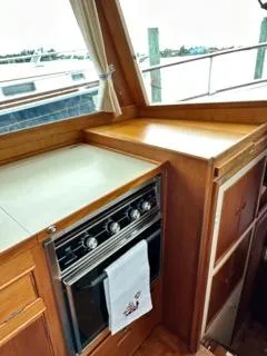 Slide: The Image of 1996 Grand Banks Classic yacht kitchen with stove, wooden cabinetry, and marina view. - 33