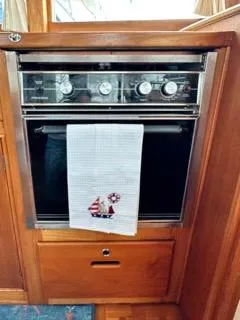 Slide: The Image of 1996 Grand Banks Classic oven with nautical-themed towel in wooden interior. - 34