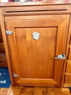 Slide: The Image of Wooden cabinet door with metal latch on a 1996 Grand Banks Classic boat. - 36
