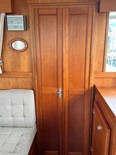 Slide: The Image of 1996 Grand Banks Classic interior with wooden cabinetry and cushioned seating. - 46