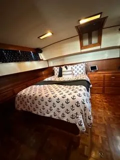 Slide: The Image of 1996 Grand Banks Classic yacht bedroom with anchor-themed bedding and wooden interior. - 47