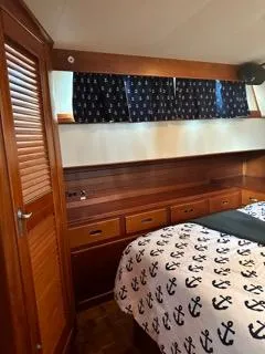Slide: The Image of Cozy 1996 Grand Banks Classic cabin with nautical-themed bedding and wooden cabinetry. - 49