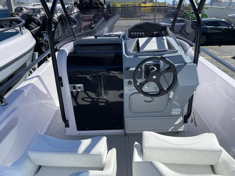 Slide: The Image of 2024 Ranieri 23S boat cockpit with steering wheel and white seating. - 12