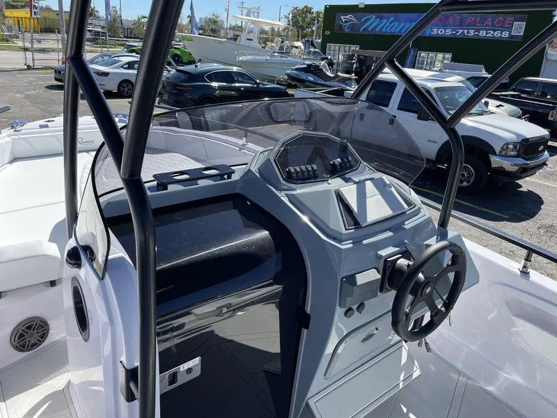 Slide: The Image of 2024 Ranieri 23S boat dashboard and steering wheel in a dealership lot. - 13