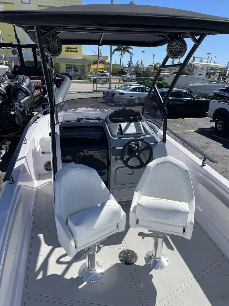 Slide: The Image of 2024 Ranieri 23S boat interior with dual white captain chairs and steering console. - 14