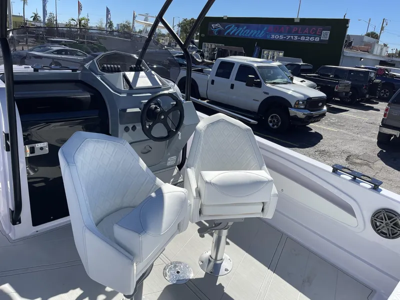 Slide: The Image of 2024 Ranieri 23S boat interior with white captain chairs and steering console. - 15