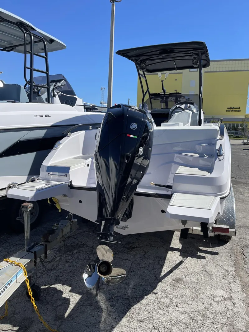 Slide: The Image of 2024 Ranieri 23S boat with outboard motor, docked on a trailer. - 16