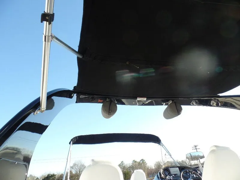 Slide: The Image of 2017 JC Sporttoon 28TT boat with black canopy and white seats. - 23