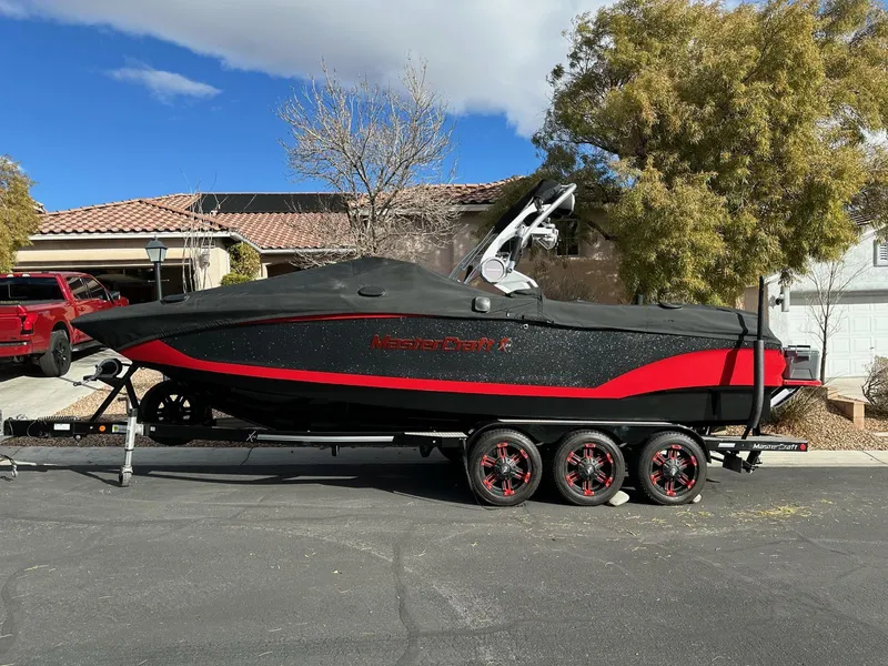 Slide: The Image of 2020 MasterCraft X24 boat with black and red design on a trailer. - 3