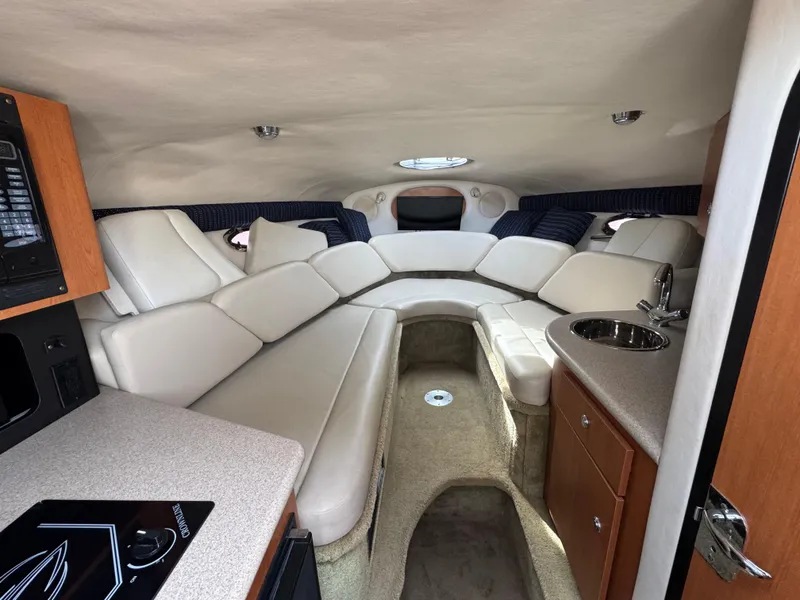 Slide: The Image of 2008 Crownline 315 SCR cabin interior with plush seating and kitchenette. - 16
