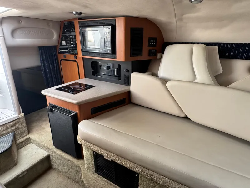 Slide: The Image of 2008 Crownline 315 SCR cabin interior with kitchenette, seating, and entertainment system. - 19