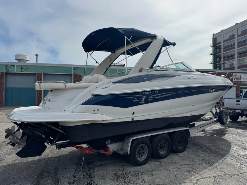 Slide: The Image of 2008 Crownline 315 SCR boat on trailer, parked outdoors near industrial buildings. - 3