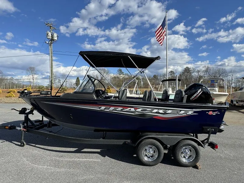 Slide: The Image of 2024 Tracker Targa™ V-18 Combo boat on trailer with American flag in background. - 10