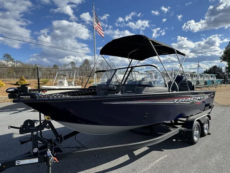 Slide: The Image of 2024 Tracker Targa™ V-18 Combo boat on trailer with American flag in background. - 11