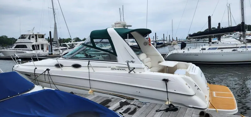 The Image of 1999 Sea Ray 290 Sundancer docked at marina, featuring sleek design and spacious deck. - 0
