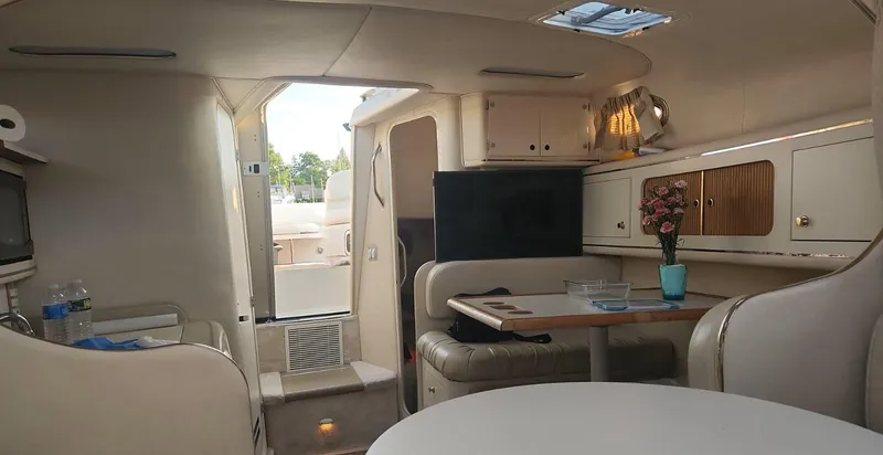 Slide: The Image of Interior of 1999 Sea Ray 290 Sundancer, featuring cozy seating and elegant decor. - 10