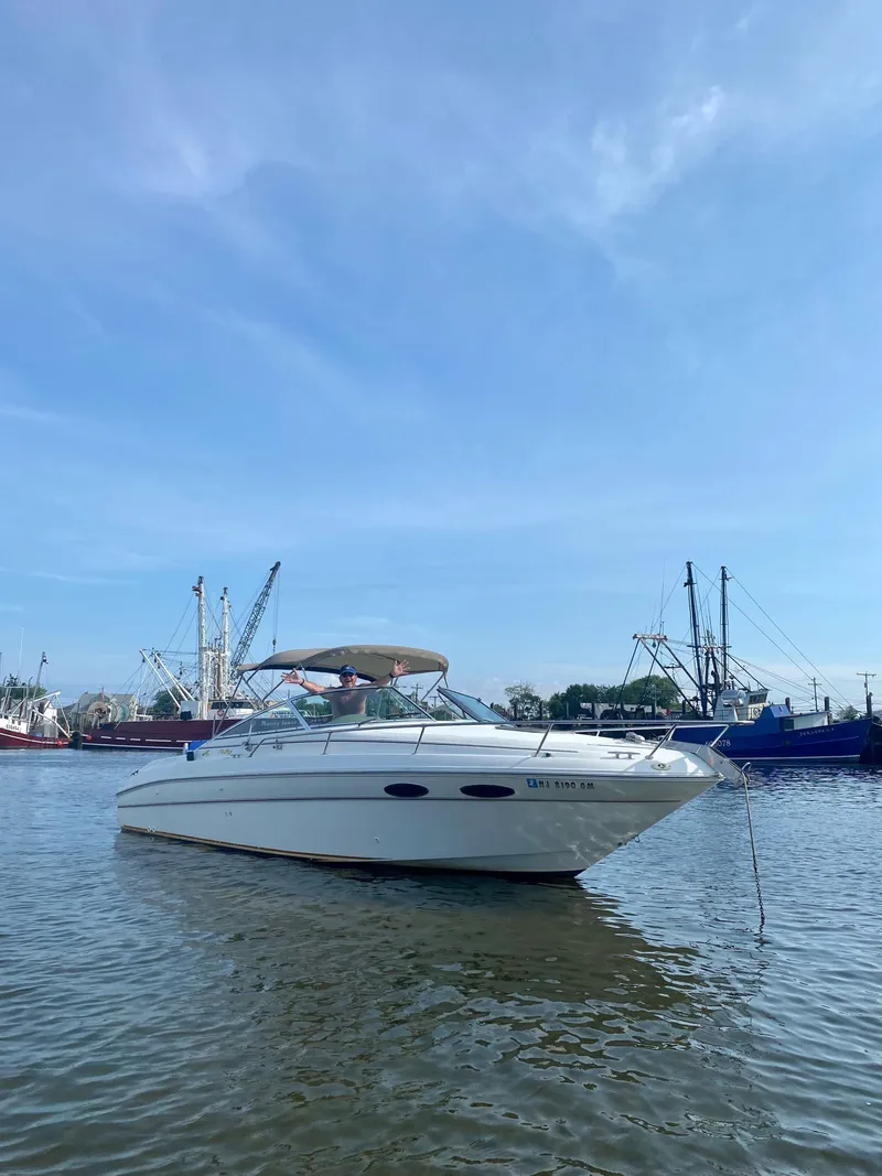 The Image of 1999 Sea Ray 280 Sun Sport boat anchored in a calm harbor. - 0