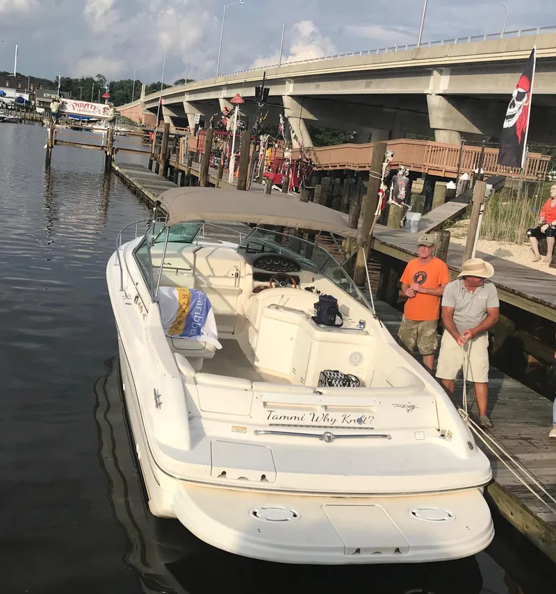 Slide: The Image of 1999 Sea Ray 280 Sun Sport docked near a bridge with people nearby. - 2