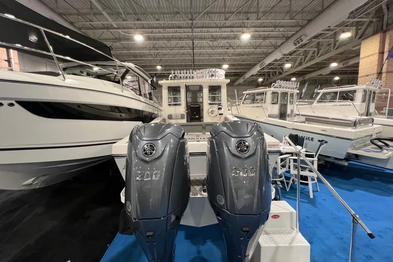Slide: The Image of 2025 Defiance 260 Admiral boat with dual engines displayed at an indoor boat show. - 5