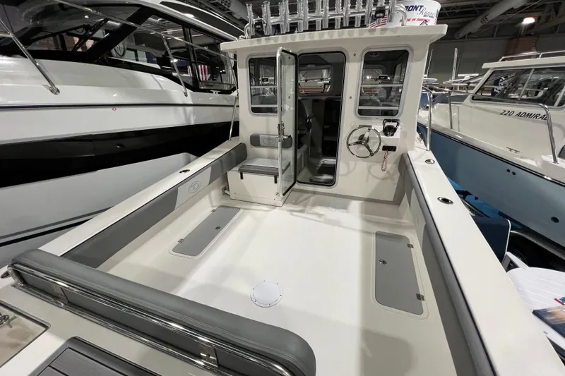 Slide: The Image of 2025 Defiance 260 Admiral boat interior with open cabin door and steering wheel. - 6
