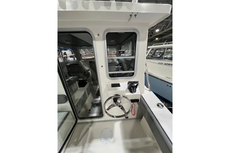 Slide: The Image of 2025 Defiance 260 Admiral boat interior with steering wheel and control panel. - 7