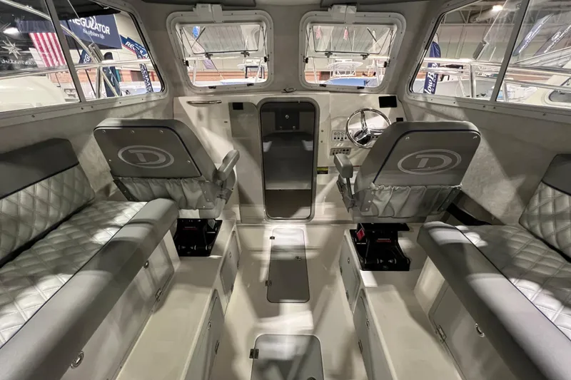 Slide: The Image of Interior of 2025 Defiance 260 Admiral boat, featuring modern seating and steering wheel. - 8