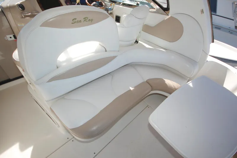 Slide: The Image of 2000 Sea Ray 380 Sundancer boat interior seating area with white and beige upholstery. - 12