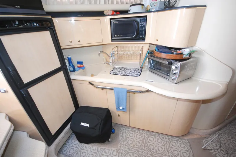 Slide: The Image of Compact kitchen area in a 2000 Sea Ray 380 Sundancer yacht with appliances and storage. - 18