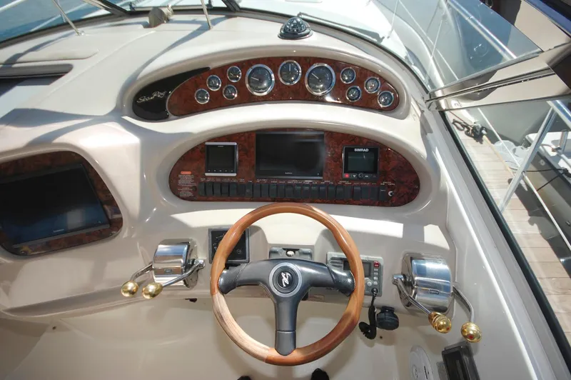 Slide: The Image of Cockpit dashboard of a 2000 Sea Ray 380 Sundancer with wooden steering wheel and control gauges. - 9
