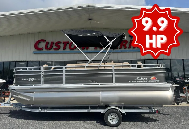 The Image of 2024 Sun Tracker Fishin' Barge 20 DLX pontoon boat with 9.9 HP engine displayed outdoors. - 1