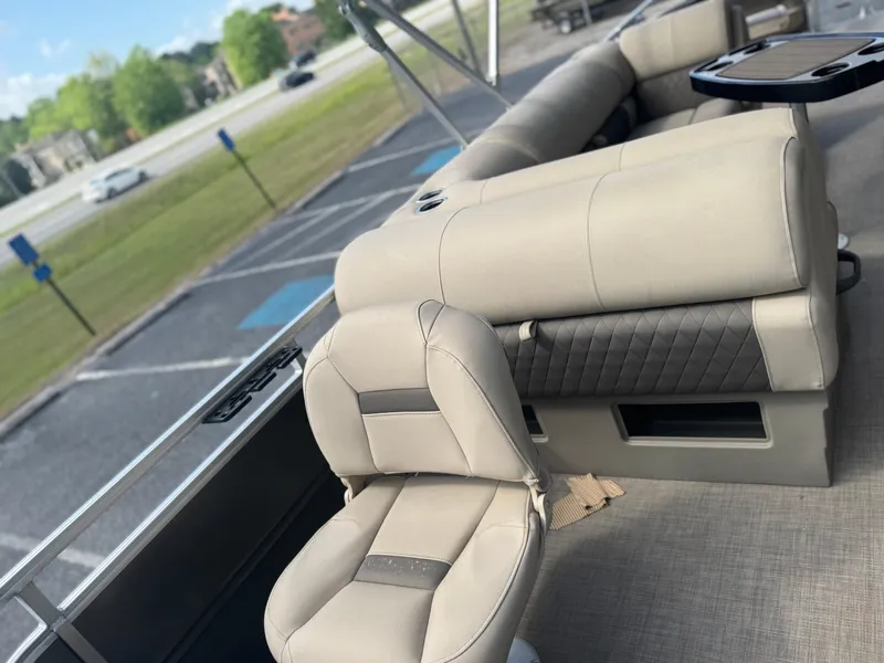 Slide: The Image of 2024 Sun Tracker Fishin' Barge 20 DLX interior with beige seating and table. - 6