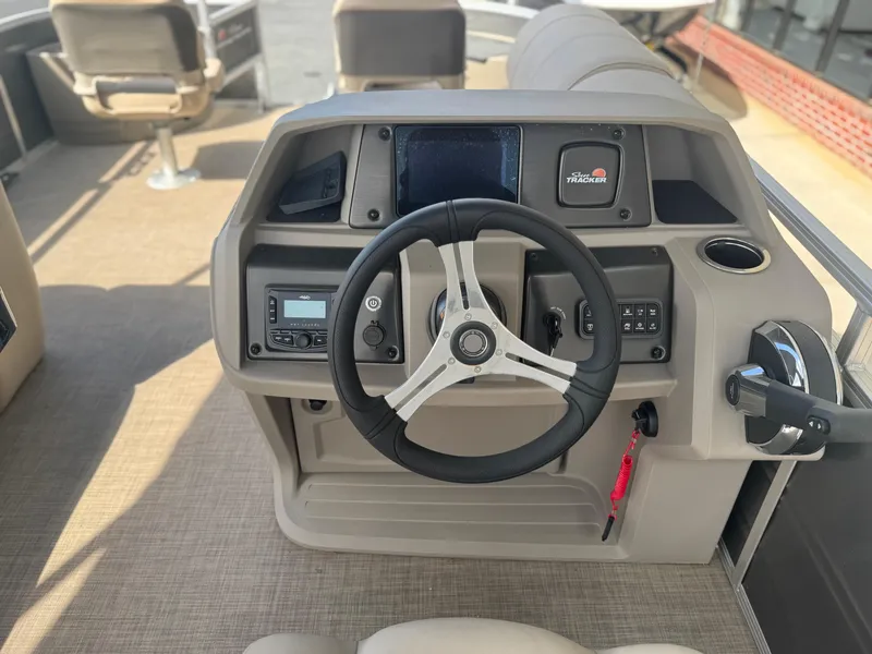 Slide: The Image of 2024 Sun Tracker Fishin' Barge 20 DLX helm with steering wheel and control panel. - 9