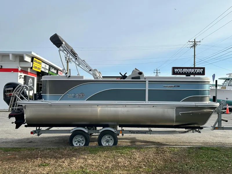 The Image of 2024 SunCatcher Select 20RC pontoon boat on a trailer, side view. - 0