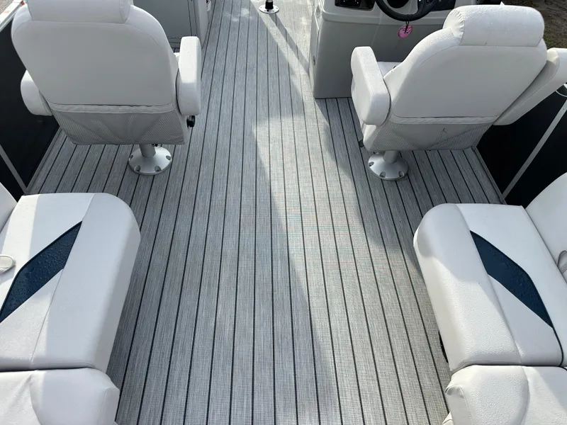Slide: The Image of 2024 SunCatcher Select 20RC boat interior with white seating and striped flooring. - 12