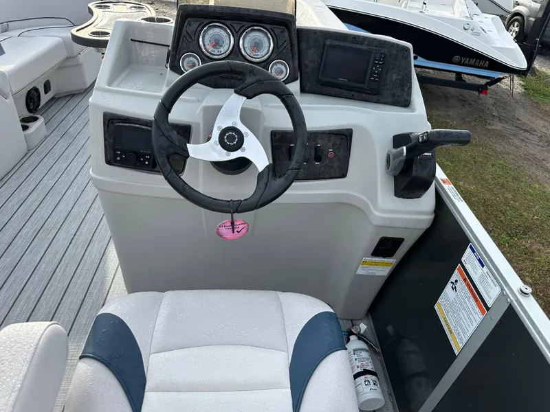 Slide: The Image of 2024 SunCatcher Select 20RC boat dashboard with steering wheel and control panel. - 13