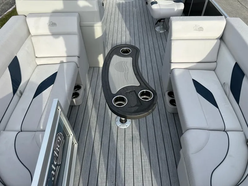 Slide: The Image of 2024 SunCatcher Select 20RC boat interior with cushioned seating and central table. - 9