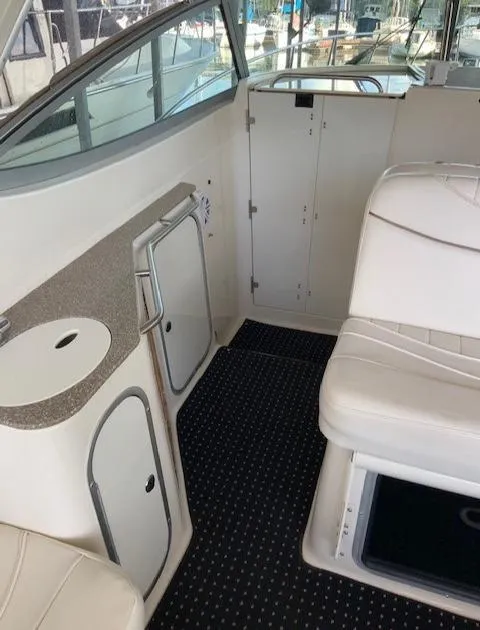 Slide: The Image of Interior of a 2000 Maxum 3300 SCR boat with white seating and storage compartments. - 10