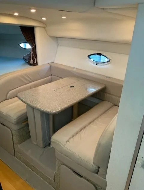 Slide: The Image of Interior dining area of a 2000 Maxum 3300 SCR yacht with beige seating and a table. - 19