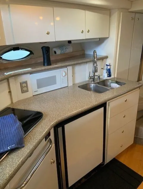 Slide: The Image of 2000 Maxum 3300 SCR yacht kitchen with sink, microwave, and storage cabinets. - 20