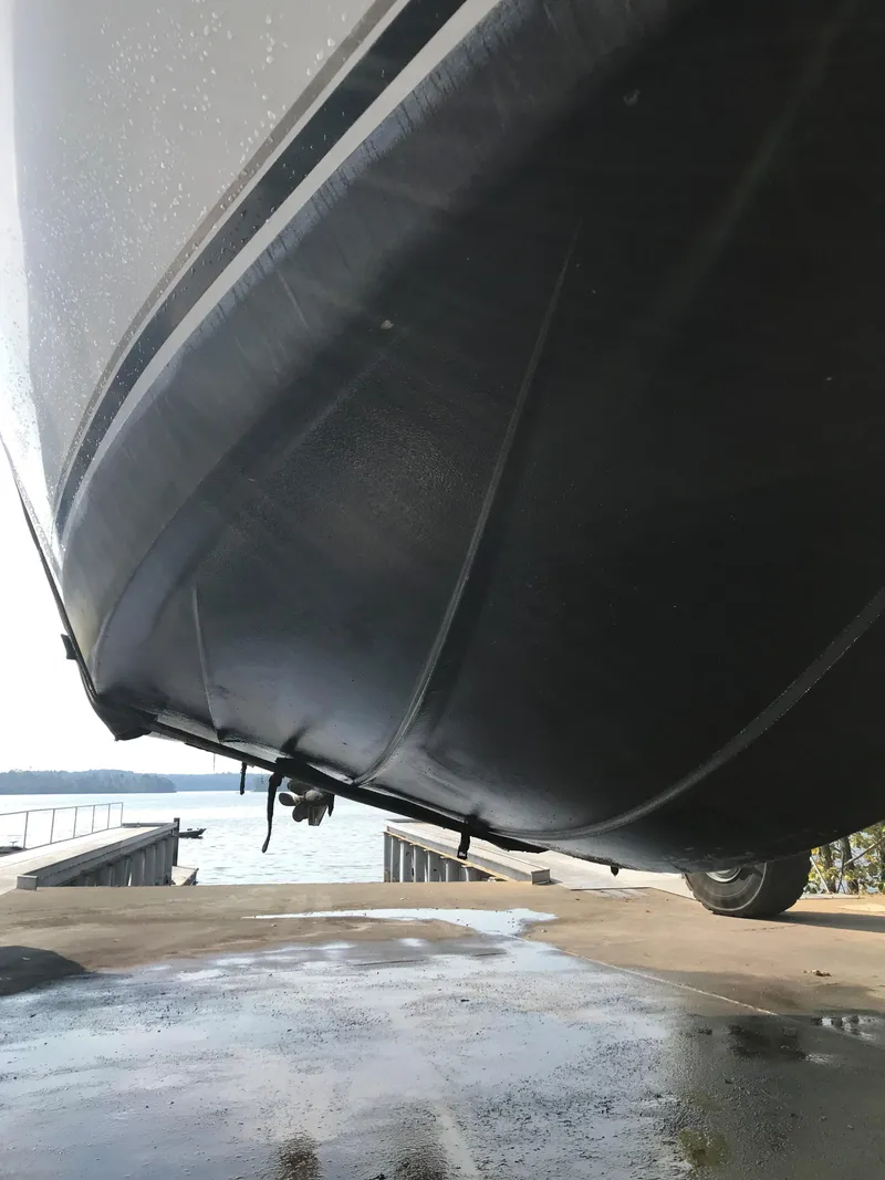 Slide: The Image of 2000 Maxum 3300 SCR boat hull on a trailer near water. - 35